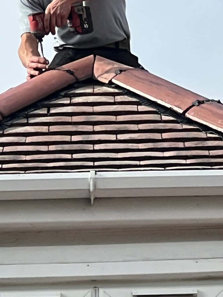 This is a photo of one of the operatives of Bingham Repairs installing new ridge tiles